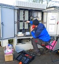 Test work on an outdoor distribution box. Technician working outside on a telecommunication distribution cabin