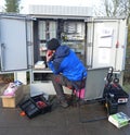 Test work on an outdoor distribution box. Technician working outside on a telecommunication distribution cabinet.