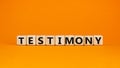 Testimony symbol. Wooden cubes with the word `testimony`. Beautiful orange background. Business, testimony concept. Copy space