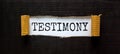 Testimony symbol. The word `Testimony` appearing behind torn black paper. Beautiful black background. Business, testimony concep Royalty Free Stock Photo