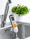 Testing a Waterproof Electronic Meter Under a Faucet Royalty Free Stock Photo