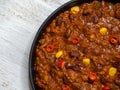 Texas chili. Chili con carne in frying pan on white wooden background. Royalty Free Stock Photo
