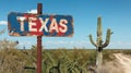 Texas road sign at state border, view of vintage rusty signpost on blue sky background, cactus in desert. Concept of travel, Royalty Free Stock Photo