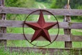 Texas rustic star on countryside side wooden fence, with road to the house slowly dissolving in the background. Royalty Free Stock Photo