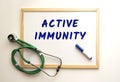 The text ACTIVE IMMUNITY is written on a white office board. Nearby is a stethoscope