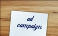 Text Ad Campaign on text, paper signs of dollar on wood table. Business concept