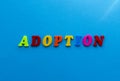 Text adoption from plastic colored letters on blue paper background