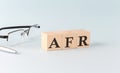 Text AFR - written on the wooden cubes on blue background