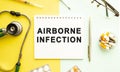 Text AIRBORNE INFECTION on notebook with stethoscope and pen on yellow background