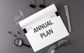 Text ANNUAL PLAN on Notebook and office tools on gray desktop Royalty Free Stock Photo