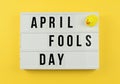 Text April Fool`s day in light box on yellow