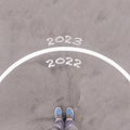 2022 and 2023, text on asphalt ground, feet and shoes on floor