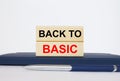 The text Back To Basic on a wooden blocks, lying on a Notepad with a metal blue pen Royalty Free Stock Photo