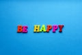 Text be happy from plastic magnetic letters on blue background Royalty Free Stock Photo