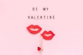 Text Be my Valentine and couple paper lips props on stick fastened clothespin heart on pink background. Concept lesbian