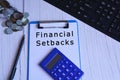 Text on blue clip board with calculator, pen, glass jar with coins and keyboard