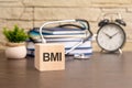 the word Body mass index is written on wooden cubes near a stethoscope on a wooden background. medical concept