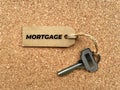 Text on brown tag with house key and wooden table background - Mortgage. Property concept. Royalty Free Stock Photo