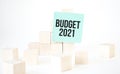 Text budget 2021 writing in green card cube ladder. White background. Business concept