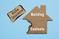 Text on burned paper house model on blue background. Home insurance concept. Royalty Free Stock Photo