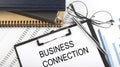Text BUSINESS CONNECTION on Office desk table with notebooks, supplies,analysis chart, on the white background Royalty Free Stock Photo
