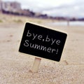 Text bye, bye summer in a signboard on the beach Royalty Free Stock Photo