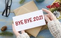 Bye Bye 2021 on white paper on red Christmas background. Farewell to 2021 concept Royalty Free Stock Photo