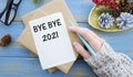 Bye Bye 2021 on white paper on red Christmas background. Farewell to 2021 concept Royalty Free Stock Photo