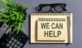 Text We Can Help on the notepad with office tools, pen Royalty Free Stock Photo