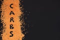 Text carbs on scattering orange pees on black background