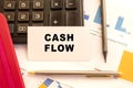 Text CASH FLOW on white card. Metal pen, calculator and financial charts. Financial concept Royalty Free Stock Photo