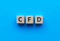 Text CFD on wooden cubes on bright blue background. Abbreviation from Contract for difference. Business