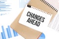 Text Changes Ahead on white paper sheet and brown paper notepad on the table with diagram. Business concept Royalty Free Stock Photo