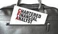 Text CHARTERED FINANCIAL ANALYST writing on white paper sheet in the black business bag. Business concept
