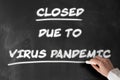 Text CLOSED DUE TO VIRUS PANDEMIC written on chalkboard