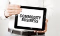 Text COMMODITY BUSINESS on tablet display in businessman hands on the white background. Business concept