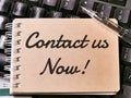 Text CONTACT US NOW written on brown paper note on computer keyboard. Royalty Free Stock Photo