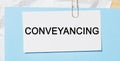 Text Conveyancing on a white card on a blue background. Business concept