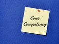 Text CORE COMPETENCY written on yellow paper note with pin board over blue background.