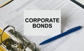 Text Corporate Bonds on a white card that is in a folder with documents and a blue pen Royalty Free Stock Photo