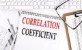 Text CORRELATION COEFFICIENT on Office desk table with keyboard, notepad and analysis chart on white background Royalty Free Stock Photo