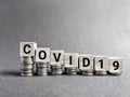 text covid-19 written on wooden blocks concept with downward stack of coins. Stock photo Royalty Free Stock Photo