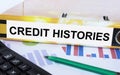 Text Credit Histories on the folder that is located on the financial diagrams with green pen and calculator