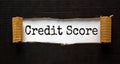 The text `credit score` appearing behind torn black paper. Business concept