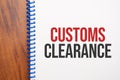 Text CUSTOMS CLEARANCE written in notepad, Office wood table from above, concept image for blog title or header image. Aged Royalty Free Stock Photo