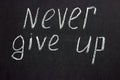 Text on a dark board `never give up`