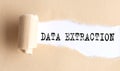 The text DATA EXTRACTION appears on torn paper on white background