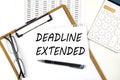 Text DEADLINE EXTENDED on the white paper on clipboard with chart and calculator Royalty Free Stock Photo