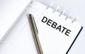 Text DEBATE on the short note texture background with pen Royalty Free Stock Photo