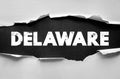 Text DELAWARE in bold distressed white type visible under torn paper. Creative typographic concept emphasizing the U.S. state name Royalty Free Stock Photo